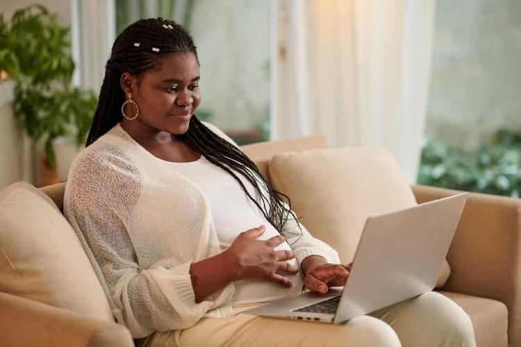 pregnant woman using her laptop